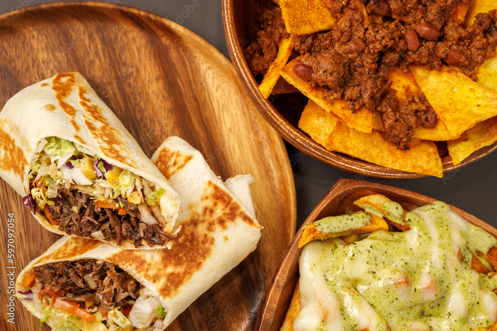 Burrito with pulled beef, nachos with chili con carne, french fries