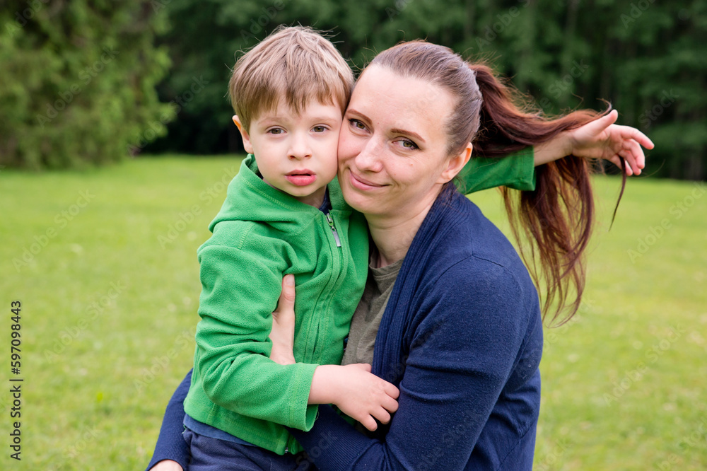 Mom and son are playing in the park. Cheerful happy family having a picnic. Vacations and trips out of town in country. Mom and son are playing in the park. Cheerful happy family having a picnic. Vacations and trips out of town in country.