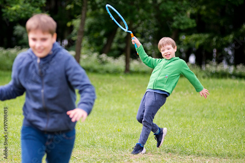 Summer holidays. Schools out. Two brothers playing with soap bubbles in the park. Cheerful happy family having a picnic. Vacations and trips out of town in nature. 