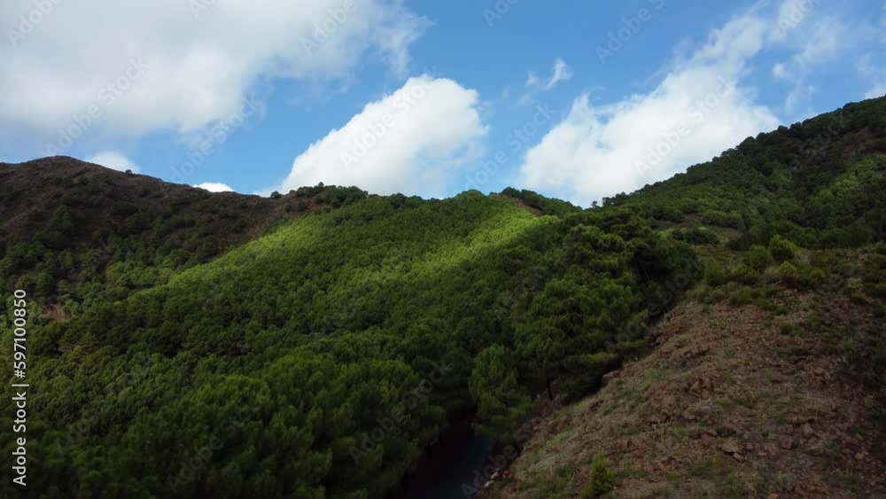 Green vibrant mountains and blue sky in Spain, aerial drone ascend view Green vibrant mountains and blue sky in Spain, aerial drone ascend view