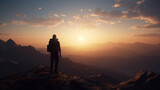Silhouette of a man with a backpack standing on the top of a mountain and looking at the sunrise