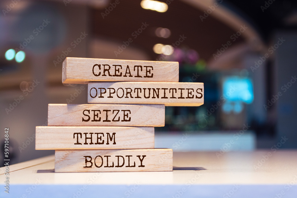 Wooden blocks with words 'Create opportunities, seize them boldly'. Inspirational motivational quote