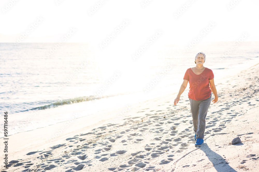 Senior woman exercising, walking at the beach