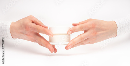 Obraz na płótnie Mock-up of beautiful woman's hand holds round jar or container of cosmetic product cream or lotion on white isolated background. Concept of beauty, spa industry, skin care. Close-up, copy space w salonie