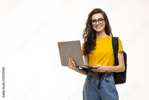 Happy student girl with backpack standing and holding laptop isolated on a white background