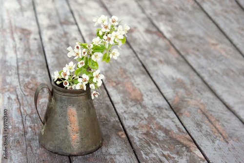 Flowers in a old antique copper pot on an old wooden table. Minimal concept of an empty object  mockup. Happy mother s day  gardener s day  florist s day.