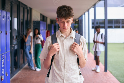 Unhappy Teenage Boy Outdoors At High School Being Teased Or Bullied