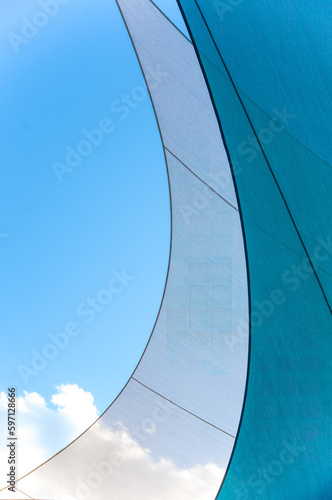 Sailboat sails abstract against a bright blue sky. Photography