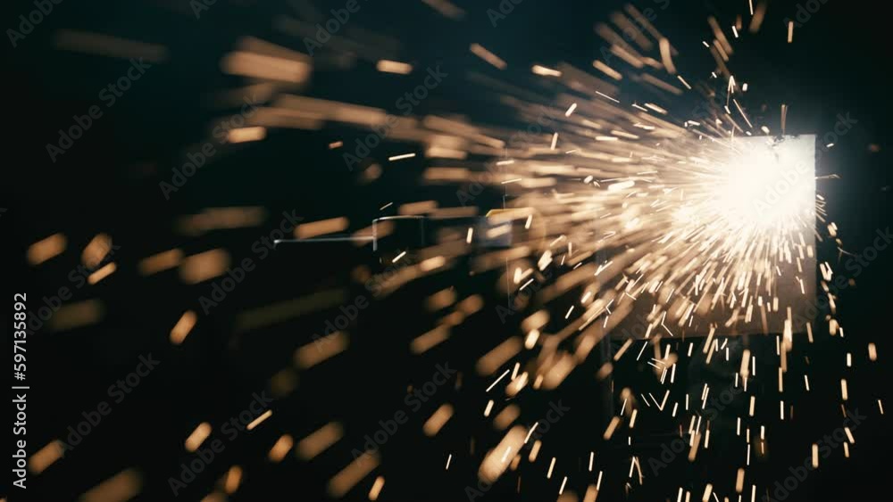 Slow motion: laser cutting, working with a metal workpiece with sparks in a factory. Metalworking, machining, industry, equipment, technology, production concept