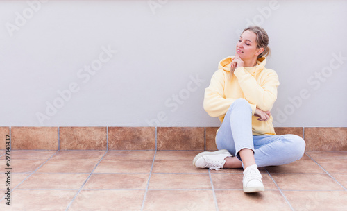 pretty caucasian sitting  woman smiling happily and daydreaming or doubting, looking to the side