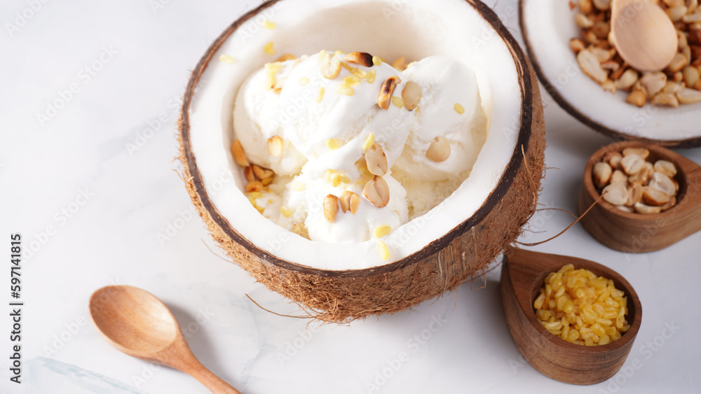 Coconut ice cream topped with roasted peanuts in a coconut shell macro shot. (spot focus) Coconut ice cream topped with roasted peanuts in a coconut shell macro shot. (spot focus)