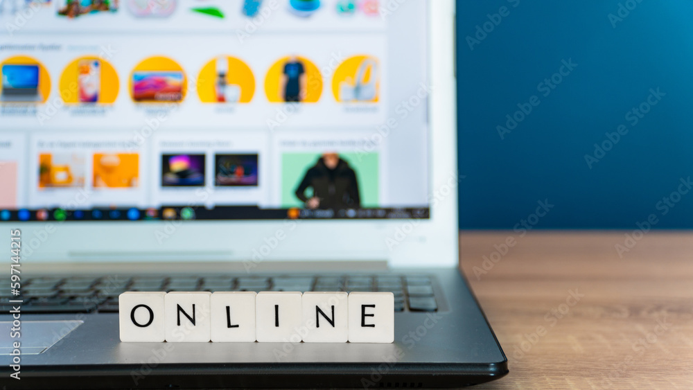Online shopping concept. Shopping cart or trolley and laptop on wooden table. Online shopping concept. Shopping cart or trolley and laptop on wooden table.