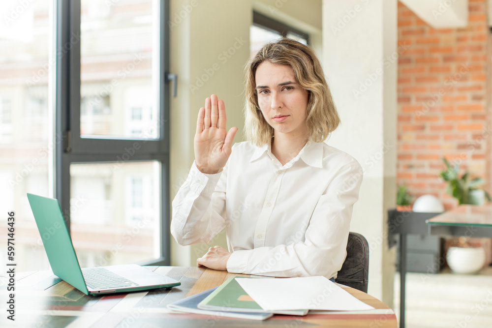 pretty woman looking serious showing open palm making stop gesture. home work telecommuting concept pretty woman looking serious showing open palm making stop gesture. home work telecommuting concept
