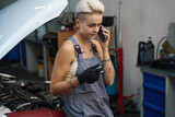Female at workplace in auto repair shop talking on phone