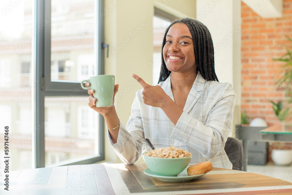 black afro woman smiling cheerfully, feeling happy and pointing to the side. breakfast concept black afro woman smiling cheerfully, feeling happy and pointing to the side. breakfast concept