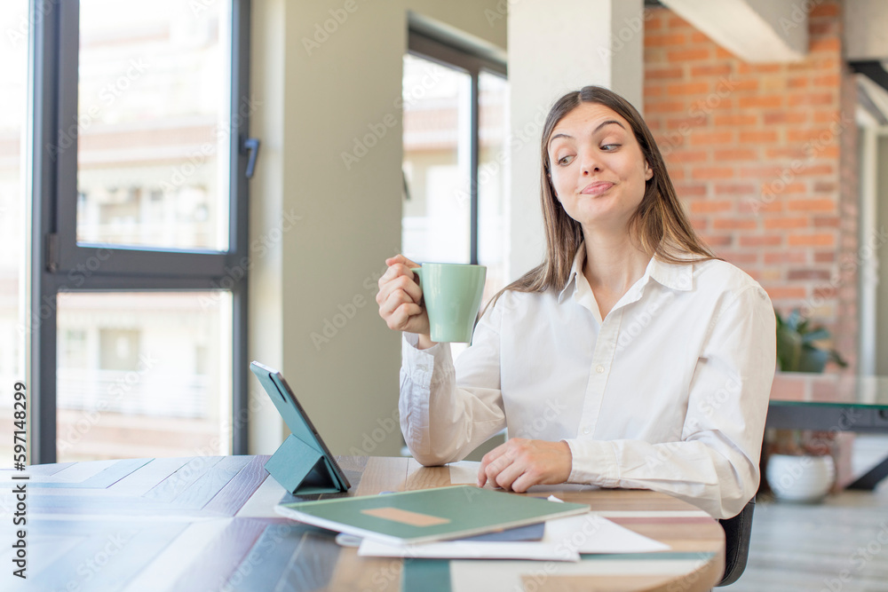 young pretty woman smiling and looking with a happy confident expression. telecommuting concept young pretty woman smiling and looking with a happy confident expression. telecommuting concept
