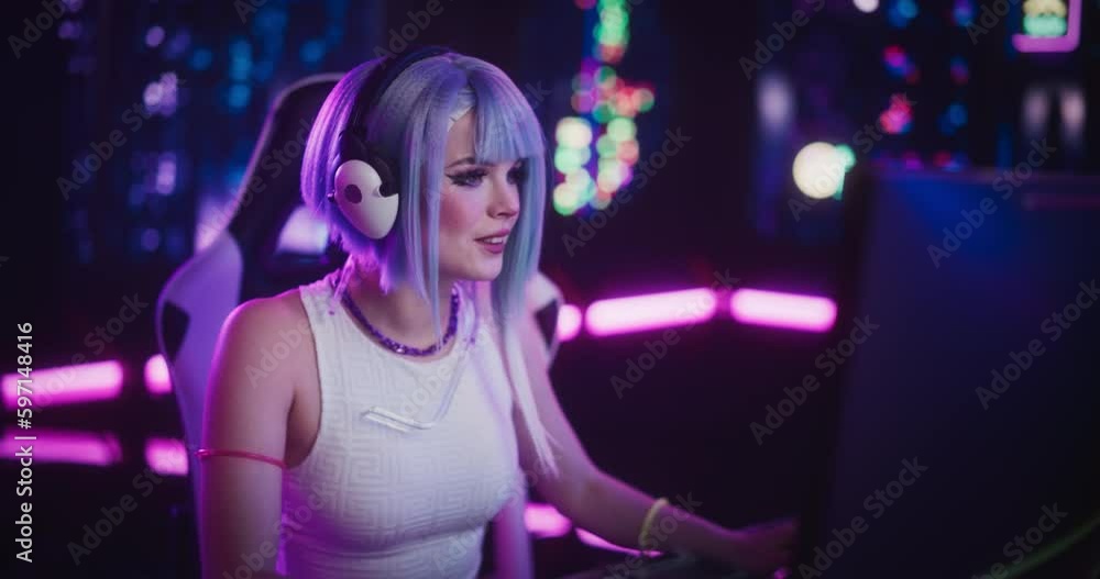 Excited Gamer Girl in Futuristic Cosplay Clothes Sitting Down to Play Video Games on Computer While Talking to Her Online Stream Audience. Gaming Concept in Cyber Reality Setting Excited Gamer Girl in Futuristic Cosplay Clothes Sitting Down to Play Video Games on Computer While Talking to Her Online Stream Audience. Gaming Concept in Cyber Reality Setting