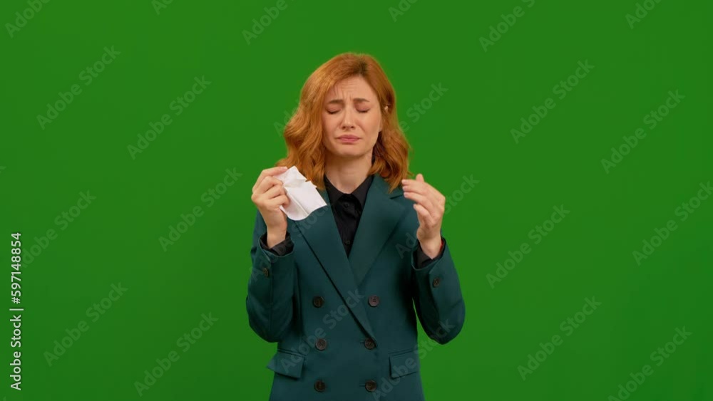 Young woman tries to stop sneezing in front of green screen background. Female in green jacket getting sick. Adult being allergic to something. Medical concept. Young woman tries to stop sneezing in front of green screen background. Female in green jacket getting sick. Adult being allergic to something. Medical concept.