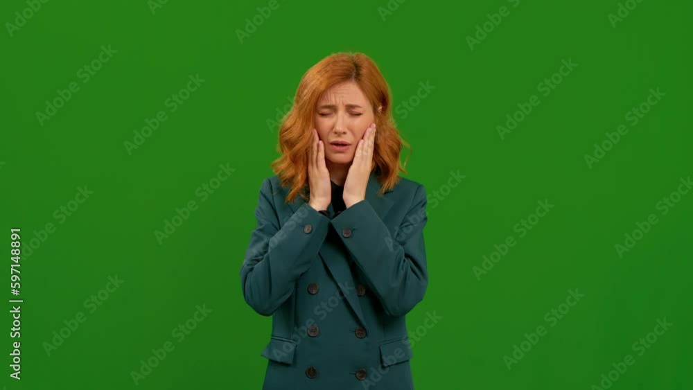 Young woman tries to stop sneezing in front of green screen background. Teeth hurting shot of red-haired worker. Medicine and health care concept. Green screen Young woman tries to stop sneezing in front of green screen background. Teeth hurting shot of red-haired worker. Medicine and health care concept. Green screen