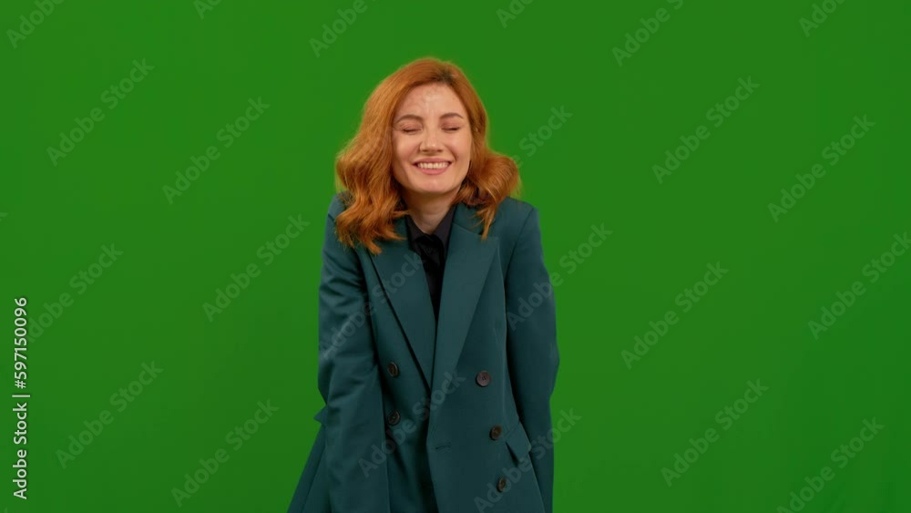 Female covers her mouth with her hand and whispers secret on green screen background. Body language gesture showed on camera. Symbols concept. Female covers her mouth with her hand and whispers secret on green screen background. Body language gesture showed on camera. Symbols concept.