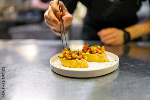 chef hand cooking Prawns, shrimp seafood bruschetta with creamy cheese on restaurant kitchen