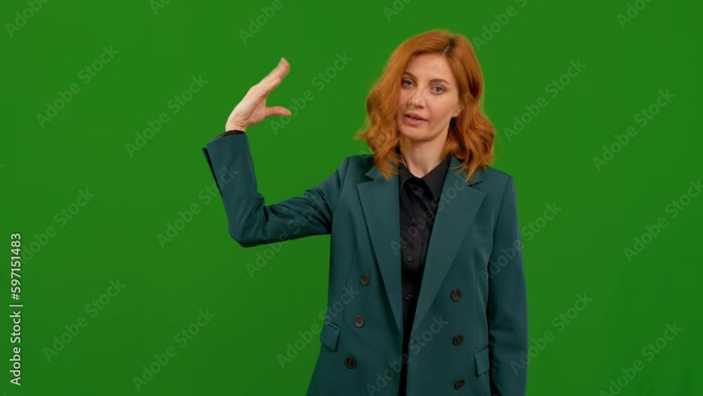 Portrait of young woman doing bla-bla-bla gesture while standing in front of the camera on the chroma key background. Bored female by a non- productive conversation. Portrait of young woman doing bla-bla-bla gesture while standing in front of the camera on the chroma key background. Bored female by a non- productive conversation.