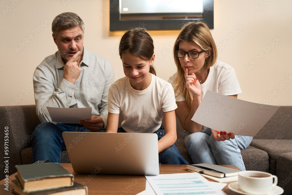 Caucasian family doing work assignments together indoors Caucasian family doing work assignments together indoors