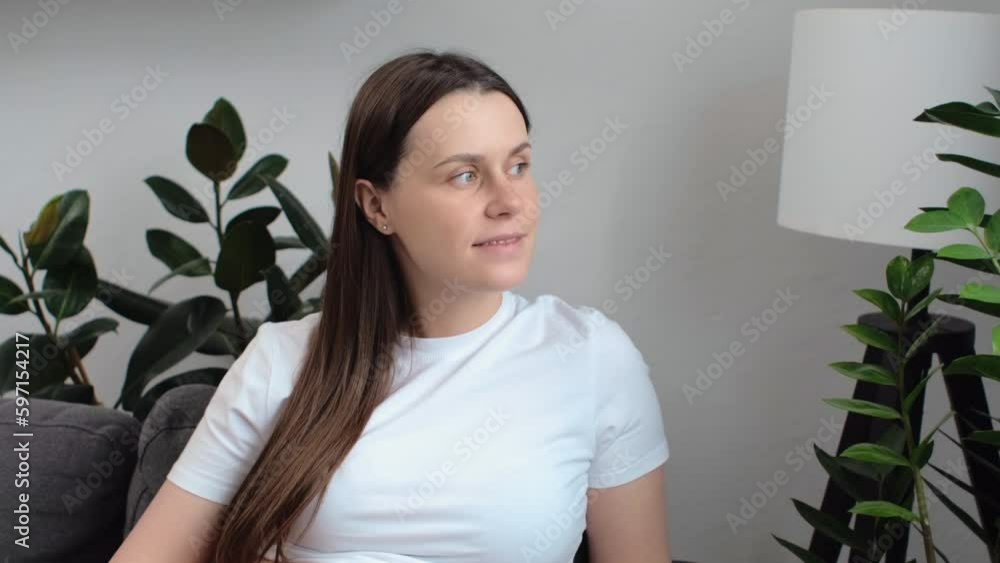 Portrait of cute peaceful young pregnant woman sitting on comfortable sofa at home stroking belly looking at window. Smiling attractive caucasian female during pregnancy happiness is expecting baby Portrait of cute peaceful young pregnant woman sitting on comfortable sofa at home stroking belly looking at window. Smiling attractive caucasian female during pregnancy happiness is expecting baby
