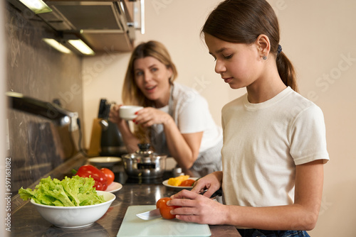 Cropped photo cute girl learning to cook breakfast for family