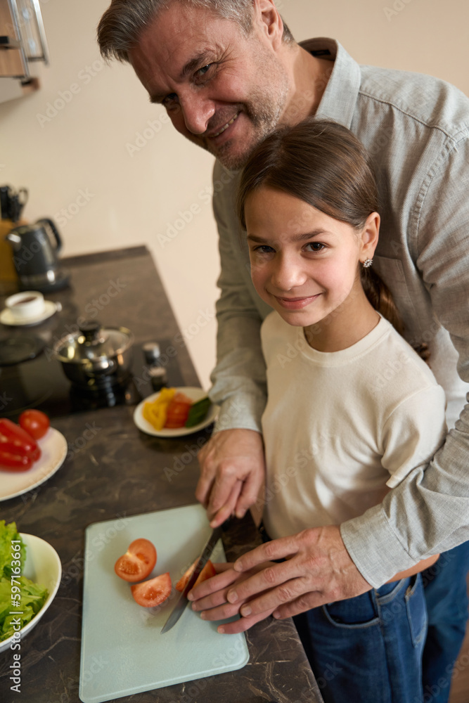 Close-up smiling daughter with father learning to cook breakfast for family Close-up smiling daughter with father learning to cook breakfast for family