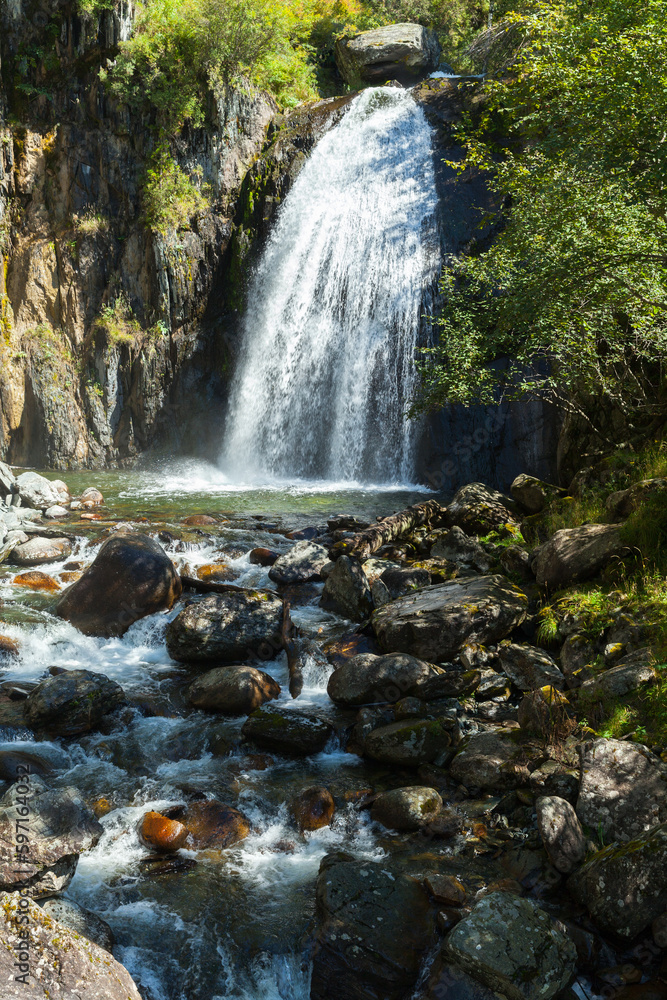Fototapeta premium Waterfall Korbu, vertical photo taken on a sunny day. Altai Republic
