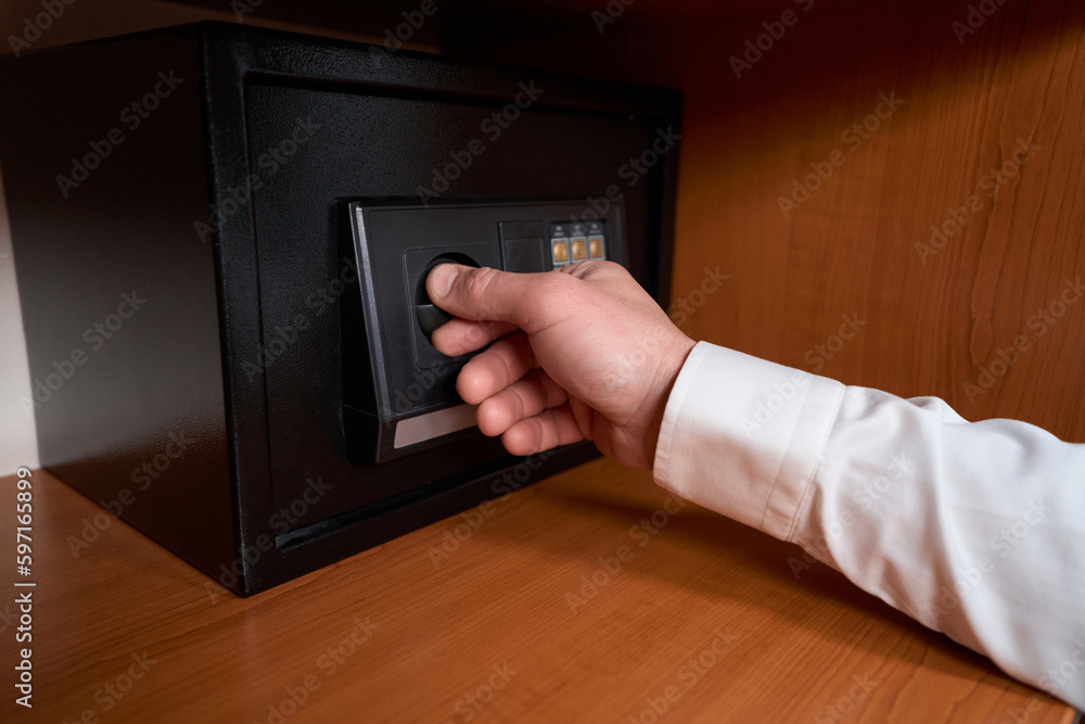 Man in shirt opening safety box with hand Man in shirt opening safety box with hand
