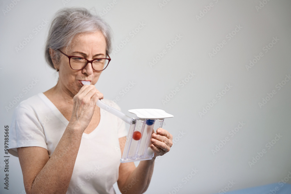 Elderly patient inflates her lungs after surgery on special simulator Elderly patient inflates her lungs after surgery on special simulator