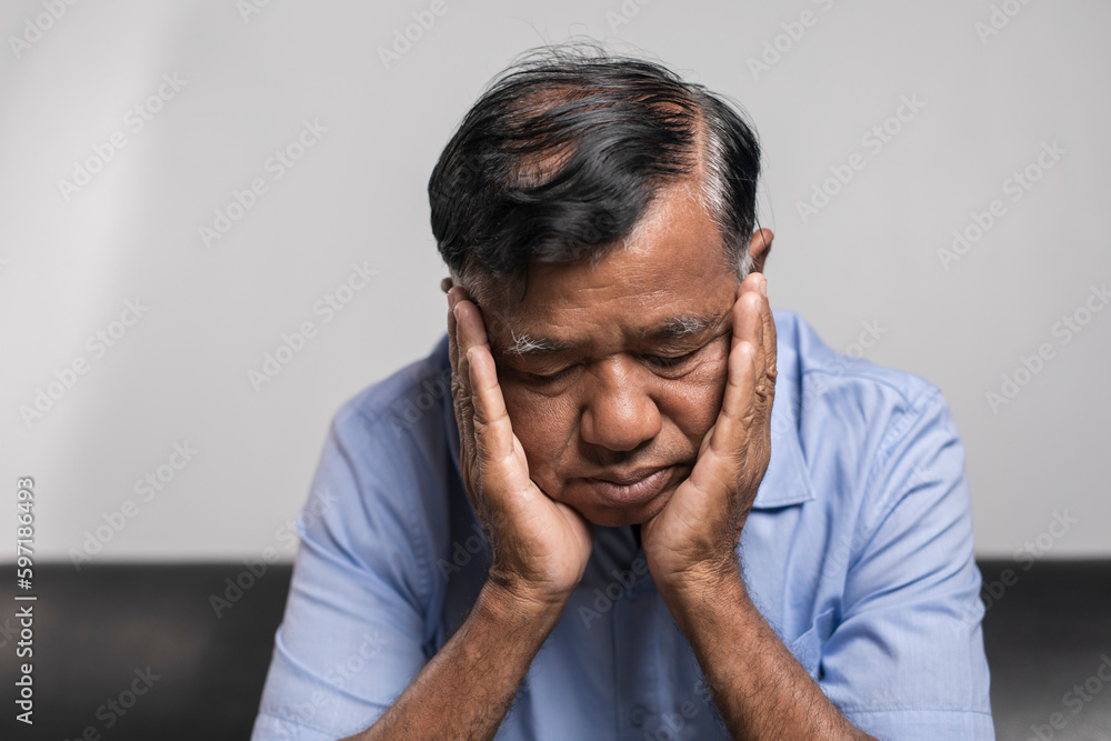 An elderly man sitting depressed alone on the sofa at home An elderly man sitting depressed alone on the sofa at home