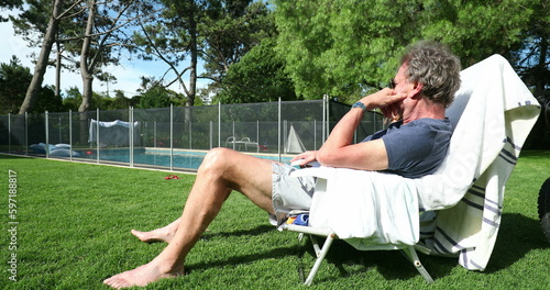 Senior man resting outside in backyard. Casual older person enjoying retirement