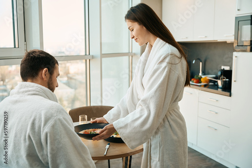 Caring wife treats her husband to traditional breakfast in pleasant environment