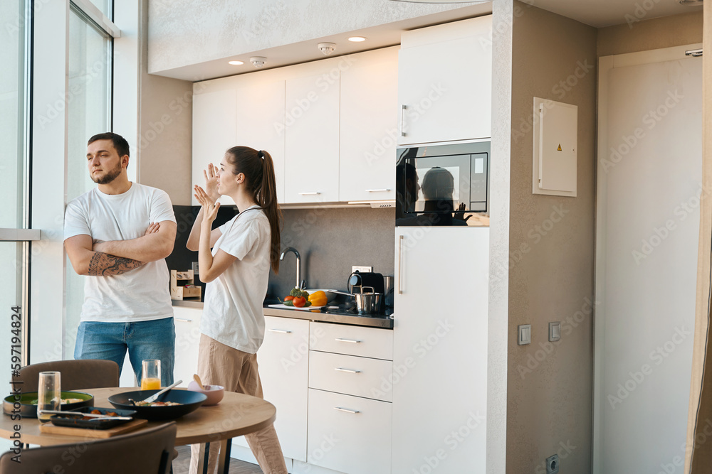 Man and a woman emotionally sort things out in kitchen Man and a woman emotionally sort things out in kitchen