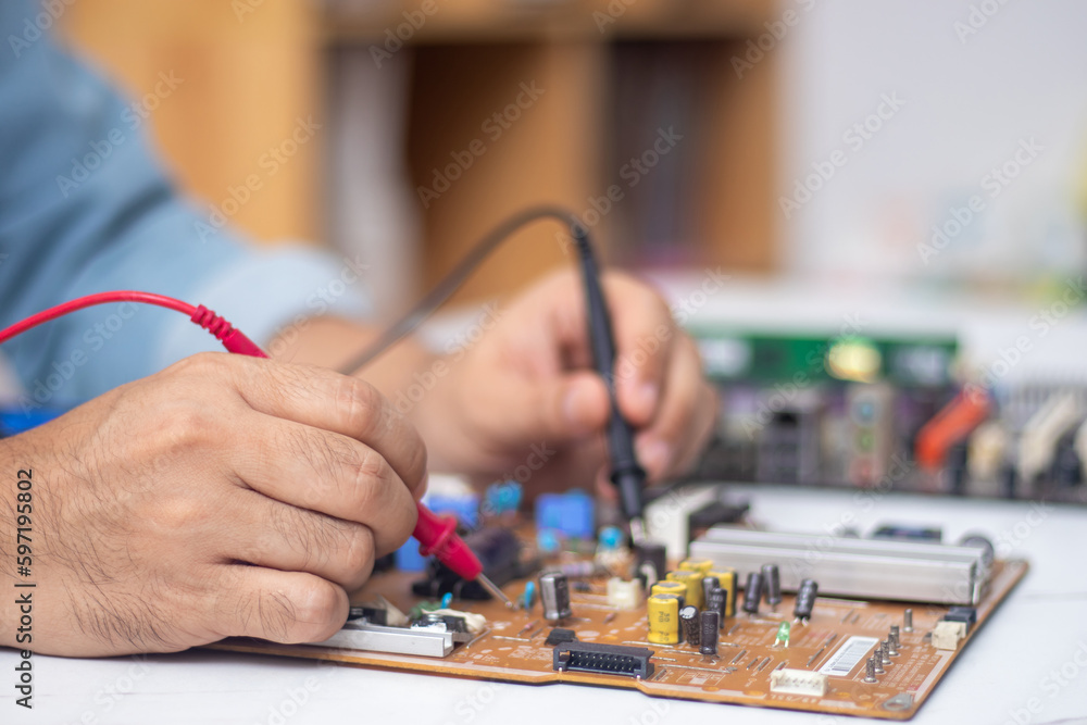 Fototapeta premium Technician using tool to measure circuit board, check and repair