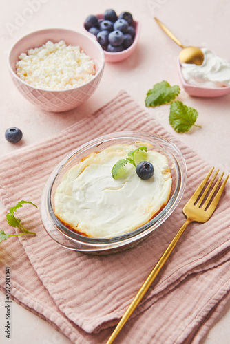 Delicious cottage cheese casserole in portioned glass forms with sour cream. Traditional Russian cuisine for breakfast - Zapekanka.