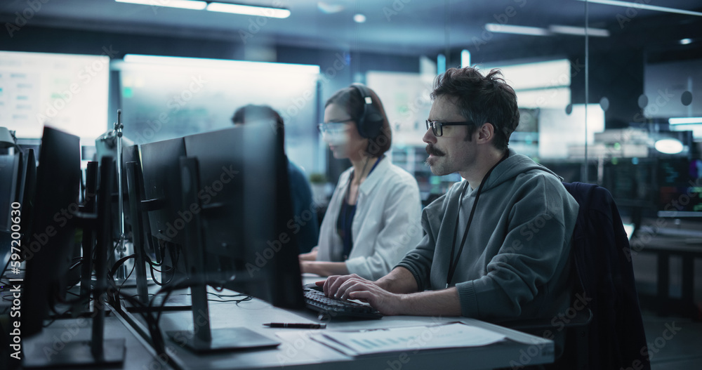 Diverse Young Colleagues Working on Computers in a Research Laboratory. Female Asking Advice from a Male Software Developer Colleague About a Solution for Their Collaborative Industrial Tech Project