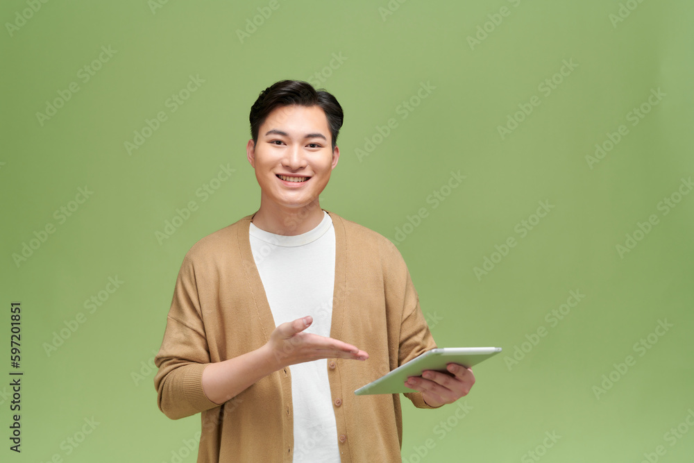 Young man using video chat on tablet against color background