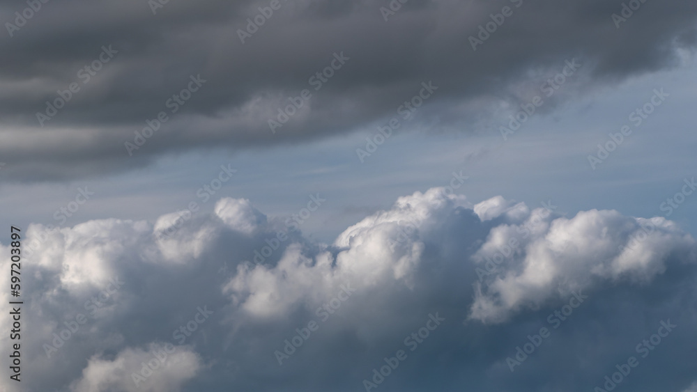 Gray cumulus clouds in the sky. Dramatic skies, landscape. The sky is like a background. White clouds, blue sky