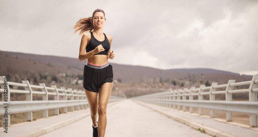 Young woman jogging on a bridge
