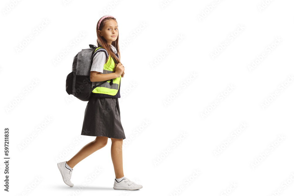 Full length profile shot of a schoolgirl wearing a reflective vest and walking Full length profile shot of a schoolgirl wearing a reflective vest and walking