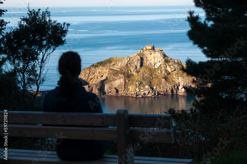 Una turista observa la vista de la ermita de Gaztelugatxe en la costa de Bizcaia, Euskadi, España.