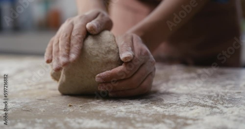 Woman hands kneading dough in the kitchen
