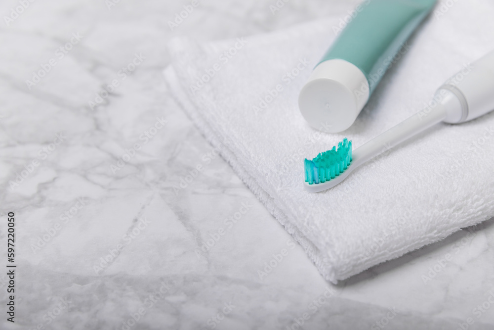 Electric toothbrush and toothpaste on a white towel on the background of the bathroom. Smart electric toothbrush. healthy teeth.Dentistry concept. Electric toothbrush and toothpaste on a white towel on the background of the bathroom. Smart electric toothbrush. healthy teeth.Dentistry concept.