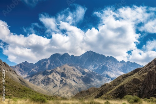 majestic mountain range with clear blue skies and fluffy clouds overhead, created with generative ai