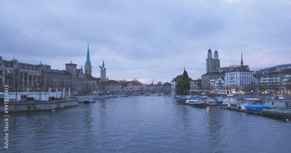 Wide shot of Zurich historic city center landmark with The Grossmunster (great minster) protestant church and the Limmat river at night, Switzerland. Swiss travel destination cityscape. slow motion. Wide shot of Zurich historic city center landmark with The Grossmunster (great minster) protestant church and the Limmat river at night, Switzerland. Swiss travel destination cityscape. slow motion.