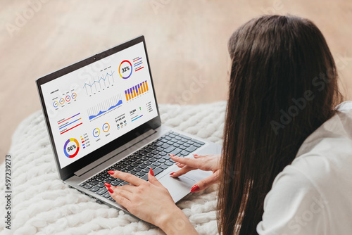 Girl financial analyst sits with a laptop on the street and checks statistics